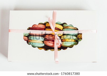 Sweet almond colorful pink blue yellow green macaron or macaroon dessert cake in gift box isolated on white background. French sweet cookie. Minimal food bakery concept. Flat lay top view copy space