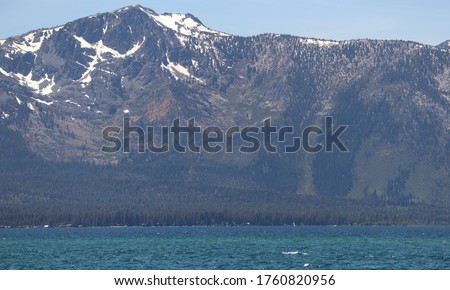 Perfect Photo that shows the Water, Forest and the Mountains with Snow on them