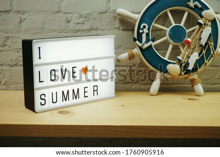 I Love Summer word in light box with mediterrean decoration on white brick wall and wooden background