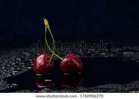 Close-up view of ripe organic cherries with water drops on blue background . Freshness concept 