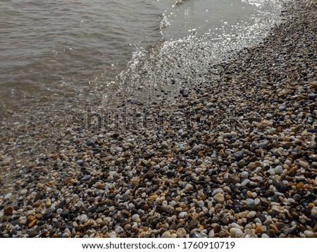 Shore of the Black Sea. In the foreground are photographs of a pebble beach and sea stretching over the horizon. Waves at sea