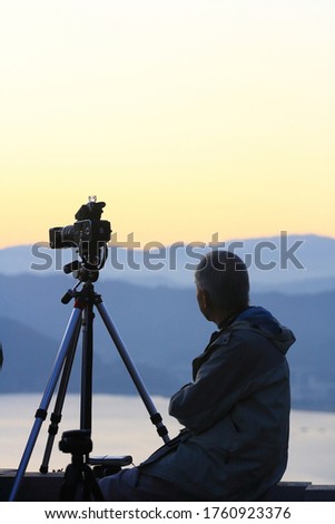 A photographer capturing sunset with his camera at Tateishi park, Suwa