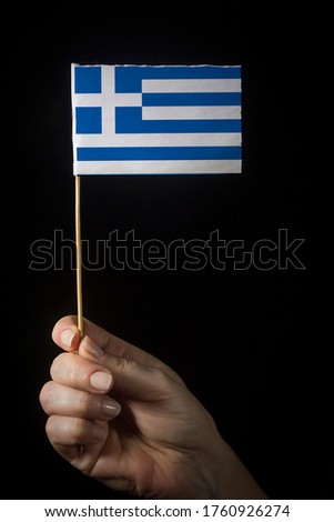 Hand with small flag of state of Greece