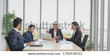 Senior executive business woman have a meeting with team at board room in office workspace background.