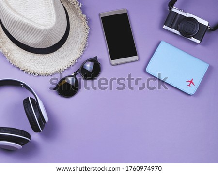 Travel concept. Top view or flat lay of passport cover and  travel accessories  on purple background with copy space.