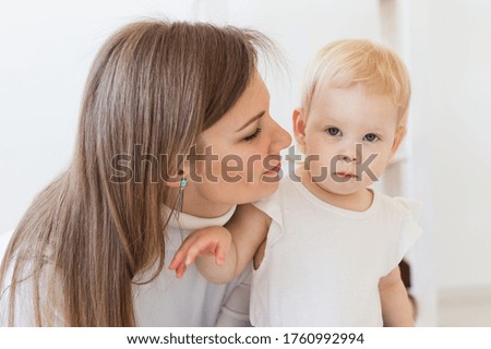 Young mother playing with her baby girl at home. Motherhood, infant and children concept.
