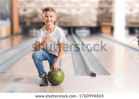 Little boy playing bowling in club