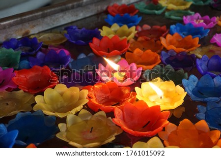 Out of focus on the light of the lotus candle in the bath as part of the ritual according to the beliefs of Thai people on the release sadness and suffering in the Temple of Thailand.