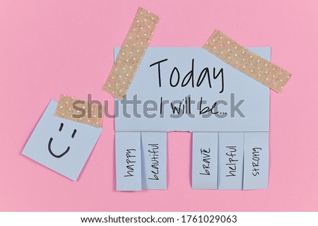 Motivational concept with blue tear-off stub note with text 'Today I will be...' and words 'happy, beautiful, brave, helpful' and 'strong' on pink background Royalty-Free Stock Photo #1761029063