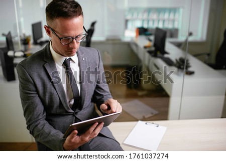 Handsome businessman working in office. Young businessman using the tablet.