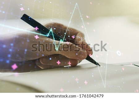 Creative abstract heart pulse hologram and man hand writing in diary on background, online medical consulting concept. Multiexposure