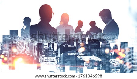 Silhouettes of business people working together in abstract blurry city. Concept of teamwork and communication. Toned image double exposure