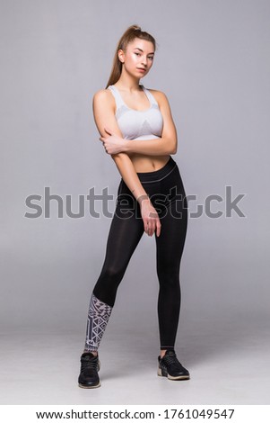 Full body of young cheerful smiling woman in sports wear, isolated over white background