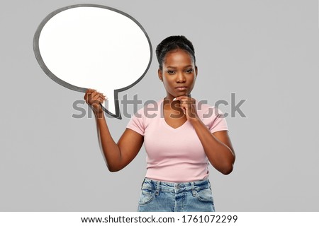 people and communication concept - african american young woman holding big blank speech bubble over grey background