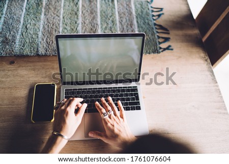Cropped image of man's hand typing text of publication for blogna dn web pages working remotely indoors, top view of businessman using laptop computer with mock up screen for searching data