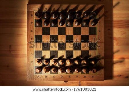 Chess board with chess pieces on a wooden table