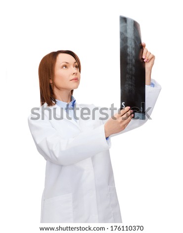 healthcare, medicine and radiology concept - serious female doctor looking at x-ray