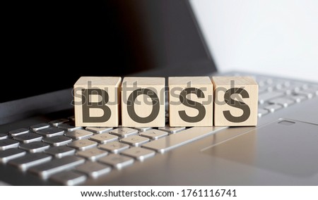 wooden blocks with BOSS text of concept on laptop
