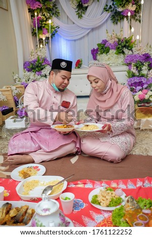 The bride couple  wearing Malay traditional  cloth  eats with their family or Makan Beradab  in wedding ceremony . Happy & Family Concept