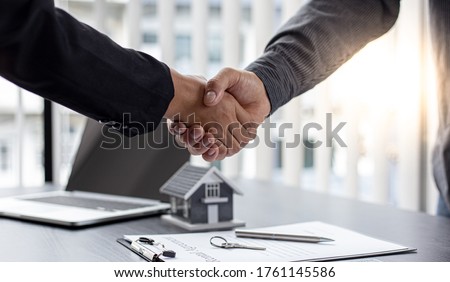 Real estate agents and customers shake hands to congratulate on signing a contract to buy a house with land and insurance, handshake and Good response concept. Royalty-Free Stock Photo #1761145586