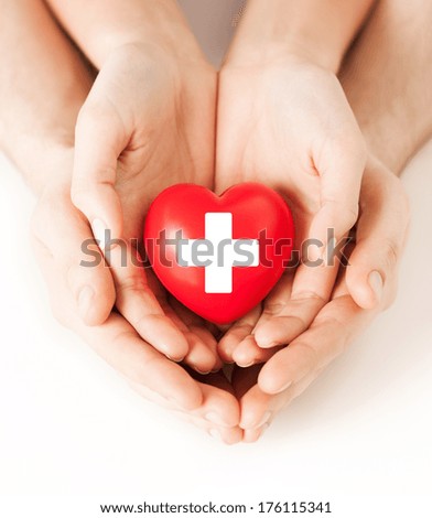 family health, charity and medicine concept - male and female hands holding red heart with cross sign Royalty-Free Stock Photo #176115341