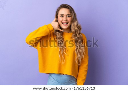 Young Brazilian woman isolated on purple background making phone gesture. Call me back sign
