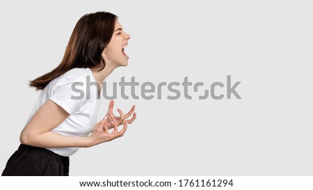 Mad woman portrait. Horror frustration. Insane lady isolated screaming at light empty space. Royalty-Free Stock Photo #1761161294