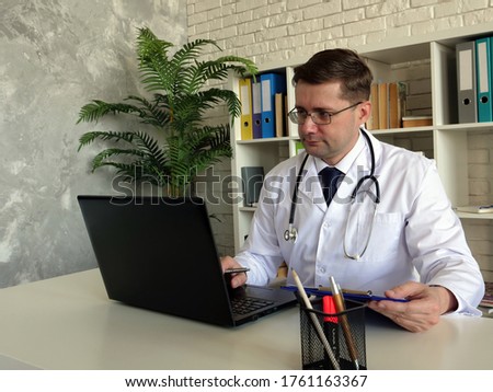 Telemedicine concept. A Doctor works with laptop.