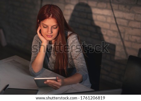Woman having a conference call using a tablet computer while working remotely from home