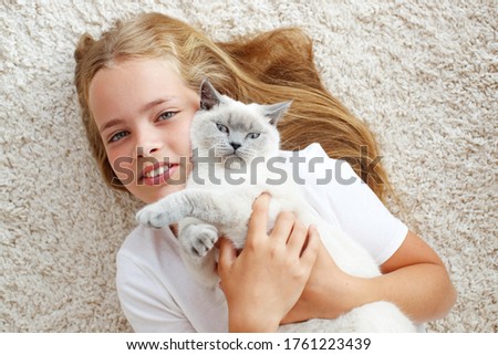 A child with a cat at home. Little girl with an animal.