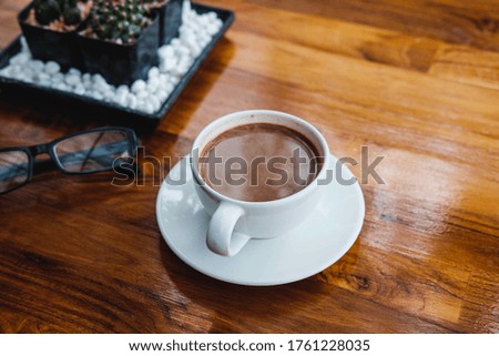 A cup of coffee on a wooden table in a coffee shop