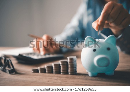   Hand holding coin with pig piggy bank. Saving and financial accounts concept