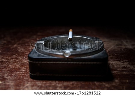 No smoking concept. Creative artwork table decoration with cigarettes. Cigarettes cause cancer and kill. Cigarette on ashtray on wooden table