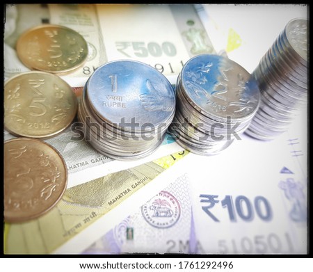 Indian new rupees currency spread randomly with all rupee coins from increasing order like growing upwards for savings in white paper background
