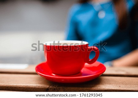 Hot coffee with latte art in a white cup with saucers on a wooden table. Cappuccino with foam. Cup of coffee on a wooden table. Top view. Place for text. Cappuccino with latte.