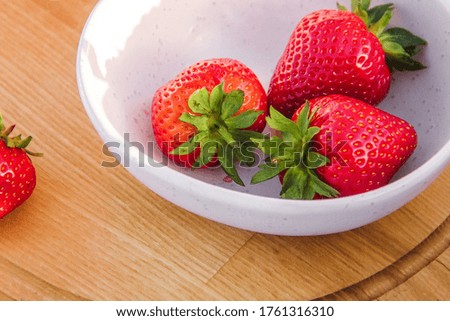 some strawberries in the white bowl on a wooden tray background. picnic concept, free space