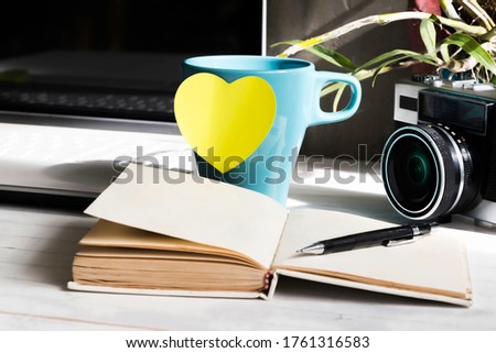 Coffee , vintage camera on wooden table with laptop and notebook