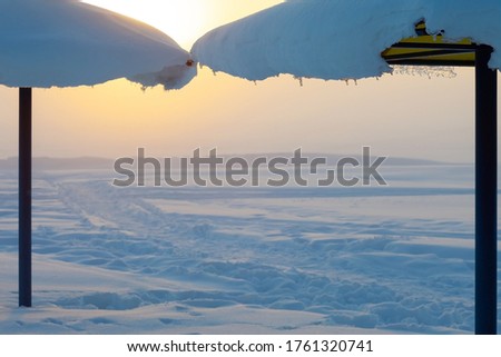 beach umbrellas in the snow at sunset, snowy landscape