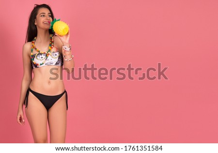 beautiful young woman in bikini,  isolated on pink background. blond girl smiling, posing with beach accessorize . beach summer concept, tropical vibe, studio shot