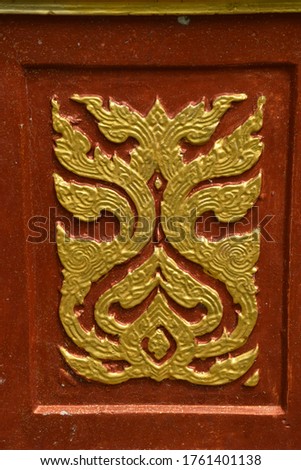 Golden Thai pattern sculpture on the temple wall