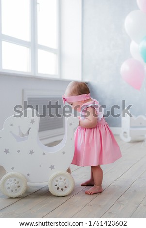 
Little girl is playing with a stroller