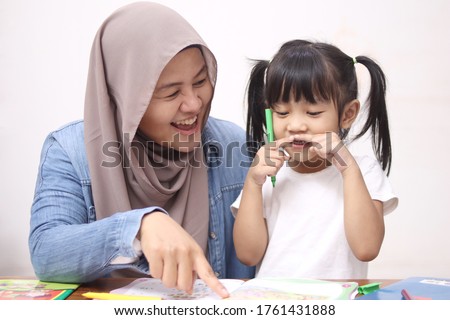 Asian muslim mother drawing with her daughter, single mom teaching baby girl, happy family concept  