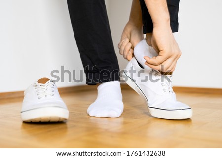 put on white sneaker shoes on wooden floor and white background Royalty-Free Stock Photo #1761432638