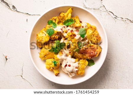 A dish of cauliflower. Spiced Baked Curry with Tahini Sauce Royalty-Free Stock Photo #1761454259