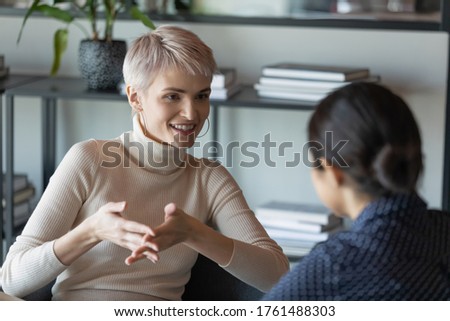 Confident short-haired businesswoman talk with client during formal meeting in office. HR manager applicant interaction at job interview communication. Two diverse mates discuss common project concept Royalty-Free Stock Photo #1761488303