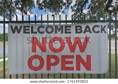 Welcome back now open sign showing businesses opening back up after covid 19 forced the shut down of the economy for months spiking cases.