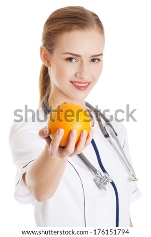 Beautiful caucasian doctor or nurse holding an orange. Isolated on white.