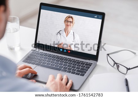 Modern treatment at home. Man watches at laptop with video woman doctor and gets consultation, close up, free space Royalty-Free Stock Photo #1761542783