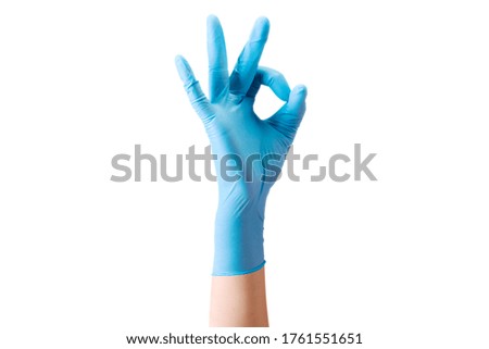 Doctor's hand in sterile medical gloves in gesture of okay or letter O isolated on white background with clipping path. Concept of protection against pandemic and viruses.