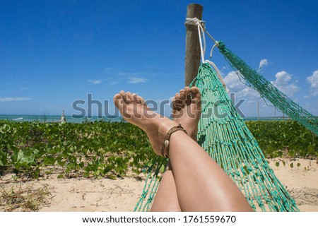 Person relaxing in hammock on the beach